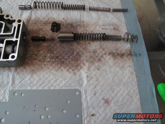 Transmission valve body disassembled with springs and plungers on a white cloth