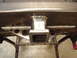 1989 Ford Bronco - Close-up of a welded trailer hitch receiver attached to a metal beam, supported by triangular brackets.
