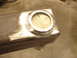 1989 Ford Bronco - Close-up view of a fabricated metal component, likely a custom part, showing a circular recess and weld seams.