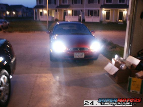 1998 Mercury Sable front view, red sedan with bright headlights and license plate 986 GHP