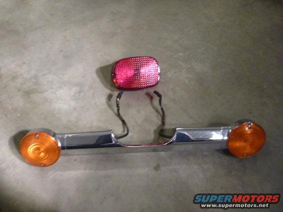 motorcycle tail light assembly with two orange turn signals and a red tail light