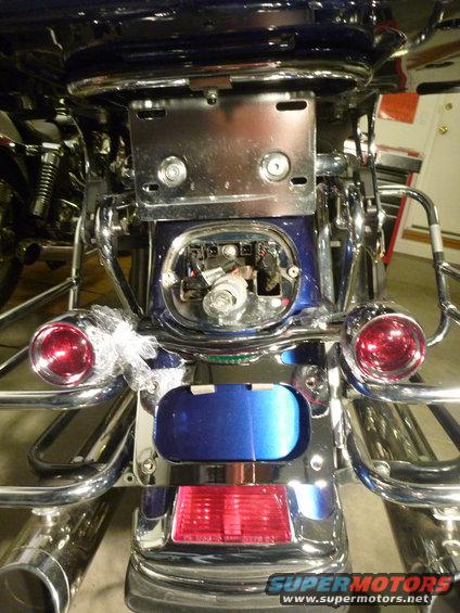motorcycle rear fender with exposed wiring and red tail lights