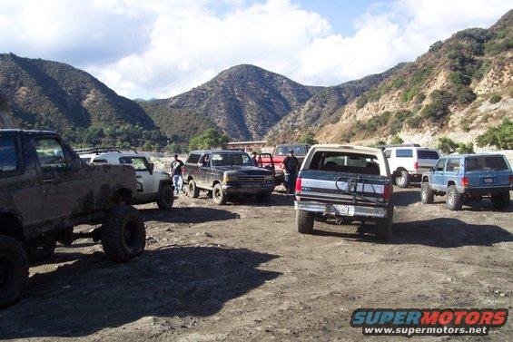 1995 Ford Bronco and other off-road vehicles parked in a dusty lot
