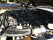 1992 Ford C-350 (Centurion Conversions) - The engine bay of a vehicle, showing the radiator, hoses, and engine components.