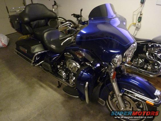 Blue 2007 Harley-Davidson Electra Glide Clsc motorcycle with black leather seat and saddlebags, parked indoors