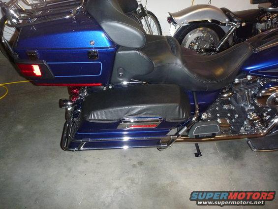 Blue motorcycle rear with saddlebags and chrome accents. Another motorcycle is visible behind it