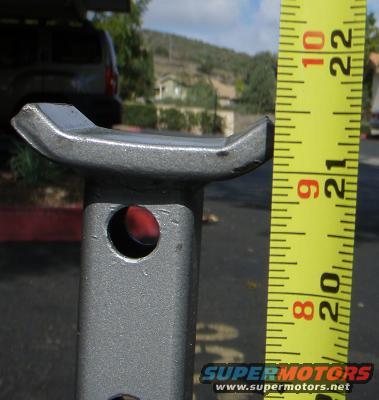 Jack stand top with tape measure showing 20-22 inches. SUV in background