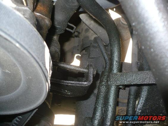 Close-up of engine bay parts, hoses, and brackets