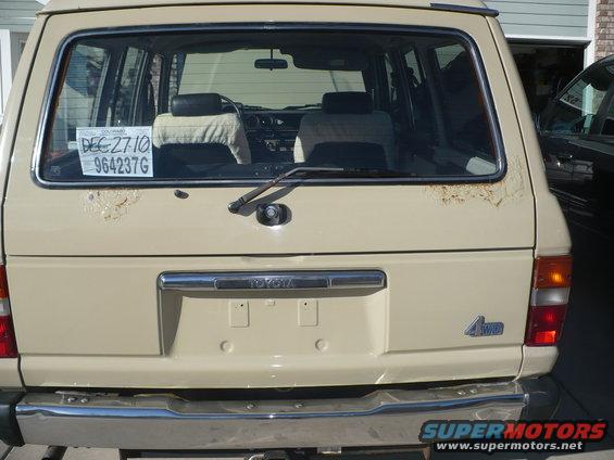 Beige SUV rear view with 4WD badge and rust spots