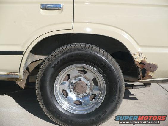 1986 Toyota Land Cruiser rear wheel well with chrome door handle and rusted quarter panel