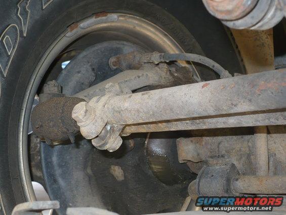 Close-up of rusty vehicle steering linkage and tire