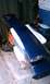 1999 Ford Mustang - Dark blue car spoiler with mounting hardware visible, resting on storage bins.