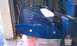 1999 Ford Mustang - A blue car spoiler is stored in a garage, resting on plastic bins.