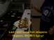 1989 Ford Bronco - A sandwich is being prepared with various toppings, including jalapenos, at a food service counter.