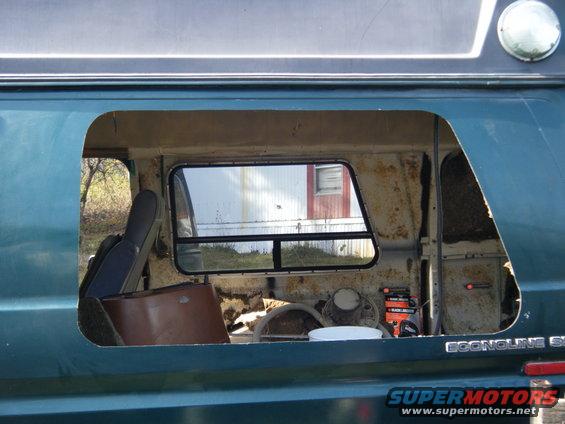 1981 Ford E350 van interior showing removed side panel, exposed metal, and items inside