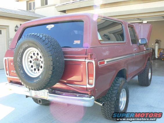Maroon 1978 Ford Bronco with a spare tire mounted on the rear, chrome bumper, and aftermarket wheels