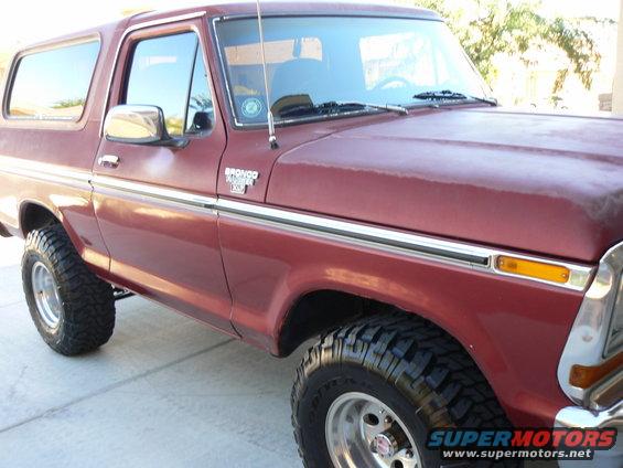 Red 1978 Ford Bronco with chrome trim and off-road tires, 3q-front view
