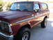 1978 Ford Bronco - Maroon 1978 Ford Bronco shown from a three-quarter front angle with chrome accents and off-road tires.