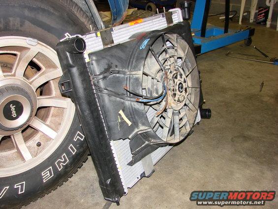 Radiator and fan assembly next to a Jeep wheel