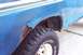 1979 Ford Bronco - Rust damage is evident on the rear fender of a blue SUV, obscuring any specific year identification.