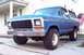 1979 Ford Bronco - A blue 1978 Ford Bronco is parked on a driveway, showing its front grille and side profile.