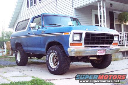 Blue 1979 Ford Bronco front 3/4 view with chrome grille and white wheels