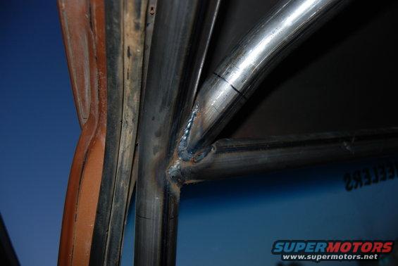Close-up of a roll cage being welded inside a vehicle's interior