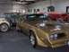 1978 Pontiac Trans Am - A gold 1977 Pontiac Trans Am is parked in a garage with other vehicles.
