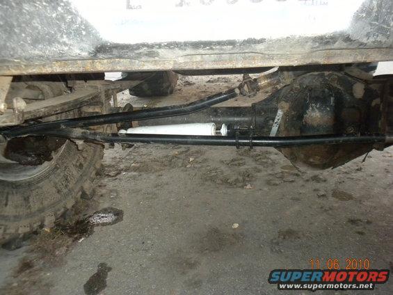 Close-up of a vehicle's rear axle, shock absorber, and steering linkage