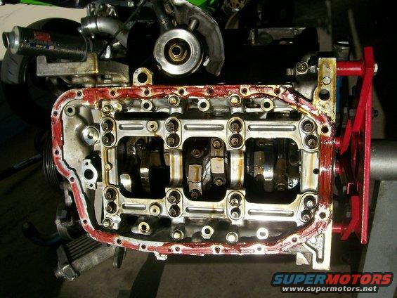 Engine block showing crankshaft and connecting rods, with oil pan gasket removed