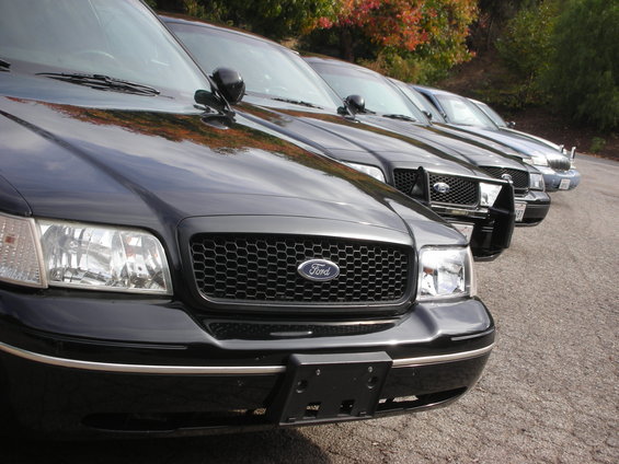 Front view of a black 2004 Ford Crown Victoria in a line of similar vehicles