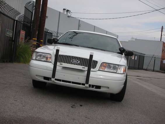 Front view of a white Ford Crown Victoria police car with a push bumper