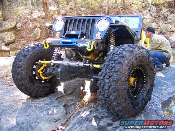 Black Jeep Wrangler with oversized tires on rocks