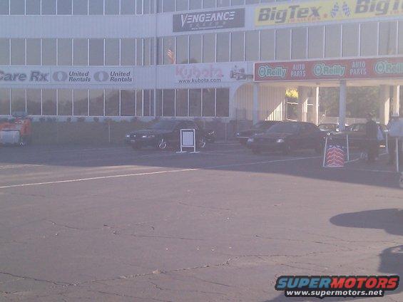 Parking lot with several cars parked in front of a building with various signs