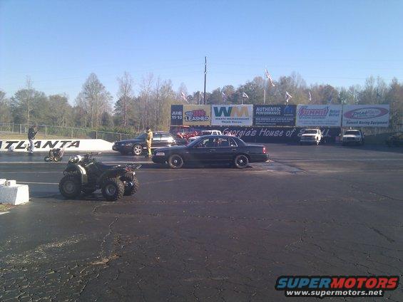 Dark 2001 Ford Crown Victoria on drag strip, side view