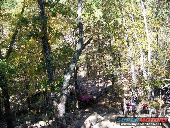 Two off-road vehicles on a rocky trail in the woods