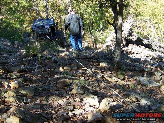 Blue off-road vehicle with winch on rocky terrain