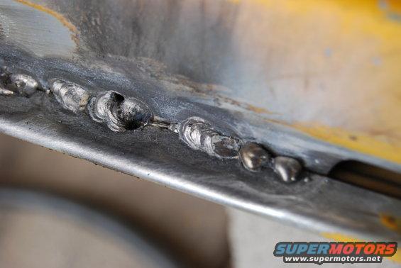 Close-up of welds on yellow and gray metal panel