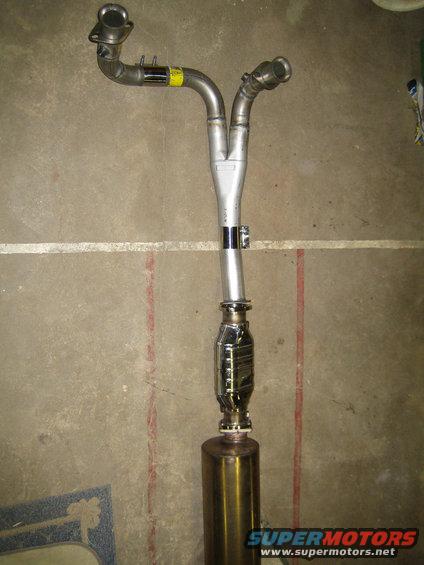 Exhaust Y-pipe assembly with a catalytic converter and muffler, laid out on a concrete floor