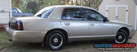 Tan 2000 Mercury Grand Marquis sedan, side view, with black wheels and tinted windows