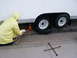 1990 Ford Bronco - A person is using a jack to lift a trailer while changing a flat tire.