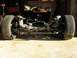 2006 Ford Crown Victoria - A front subframe assembly, complete with tires and suspension components, is elevated on jack stands in a garage setting.
