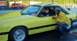 1992 Ford Mustang - A yellow 1992 Ford Mustang is parked at a drag strip with two men standing nearby. Another red vehicle is visible in the background.