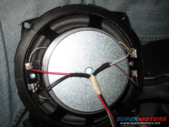 Speaker with red, black, and white wires connected to terminals
