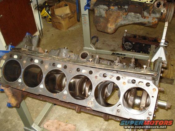 Engine block with pistons and crankshaft visible, on a stand