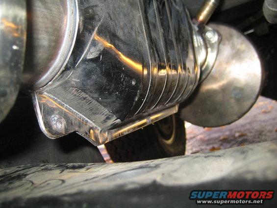 Close-up of a chrome exhaust component with ribbed detailing and a circular end cap