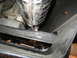 1996 Ford Bronco - A close-up view of the exhaust system and undercarriage of a vehicle.