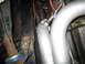 1996 Ford Bronco - Close-up view of an exhaust pipe and oxygen sensor, with visible rust on surrounding metal components.