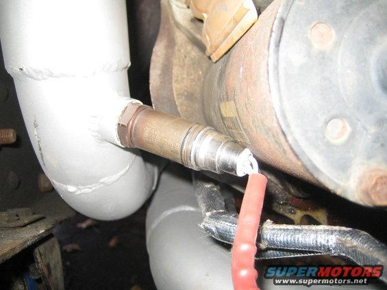 Oxygen sensor screwed into exhaust pipe, with red wire connector