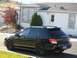 2005 Subaru Impreza - This black 2005 Subaru Impreza wagon is seen from a three-quarter front view, parked in front of a residential building.